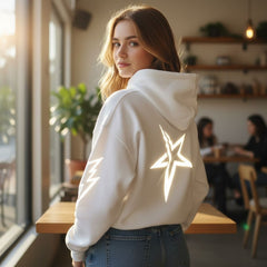 Woman wearing a white hoodie with a star design in a casual setting